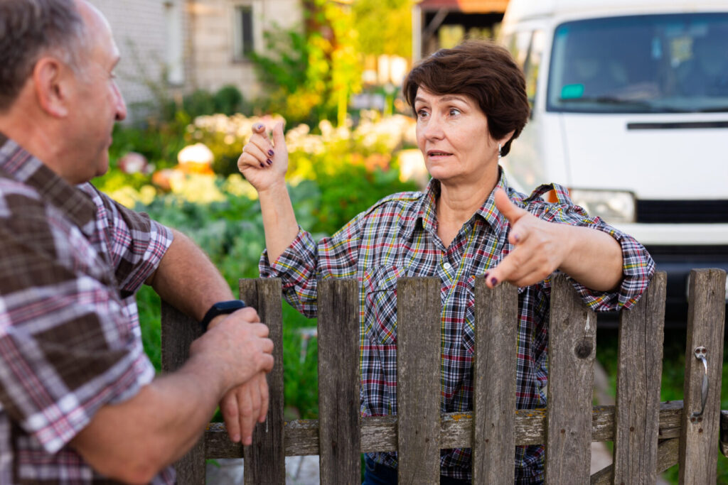 neighbors man and woman chatting near the fence - granting a neighbor an easement