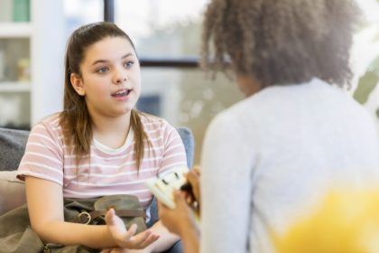 A young girl in child mediation, speaking with a mediator.