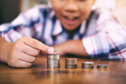 little boy stacking coins