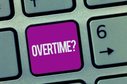A purple button on a keyboard with the word "overtime?" on it