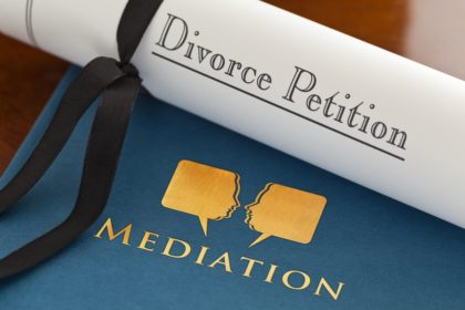 rolled paper with divorce petition on top of a folder titled "Mediation"