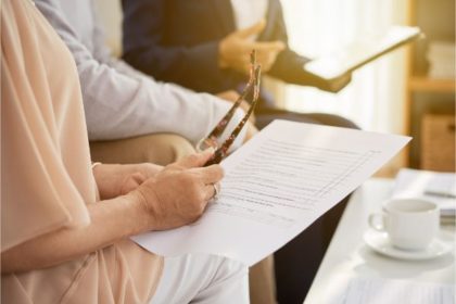 Woman reading holding her glasses