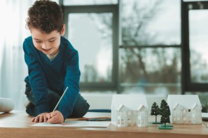 A small child writing on a piece of paper