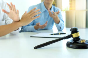 woman and man quarrel in front of gavel on the table with paper for sign