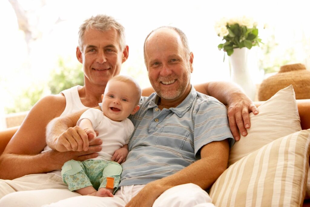 Male couple with baby learn about the types of adoption