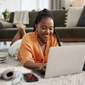 Woman laying on floor working on laptop