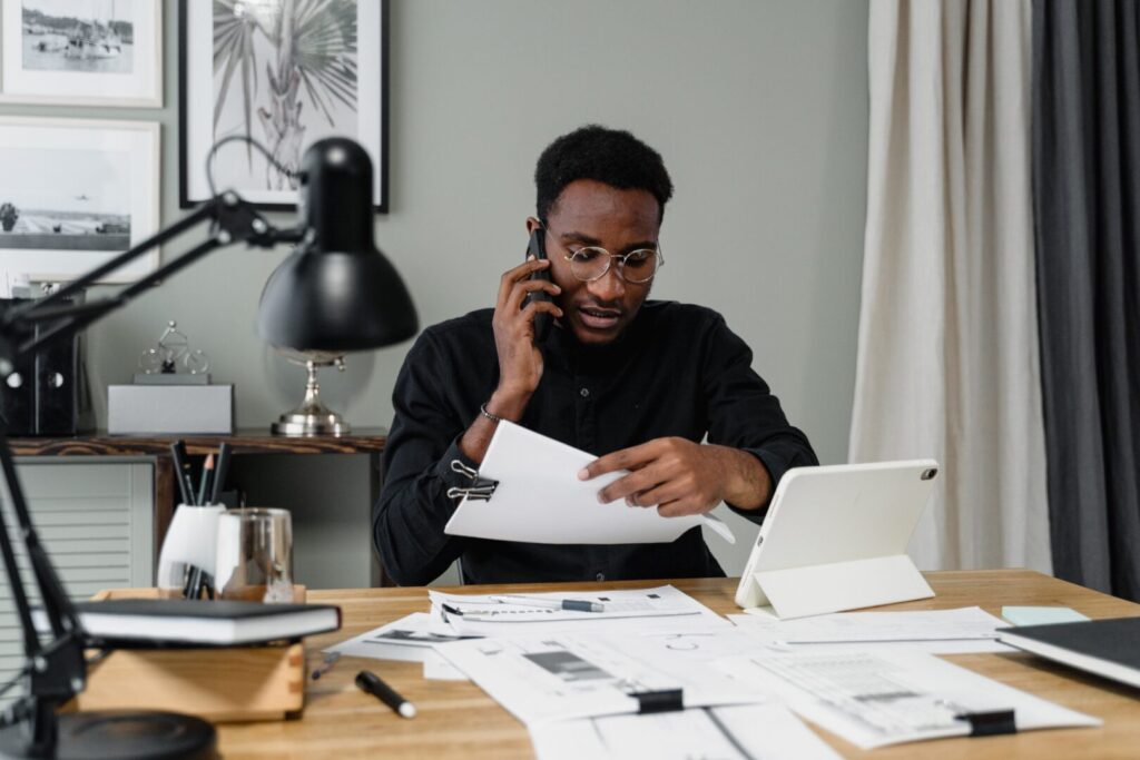 Man on cell phone working at a desk
