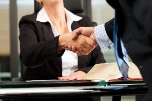 Super Lawyers & Rising Stars - client and lawyer shaking hands at desk