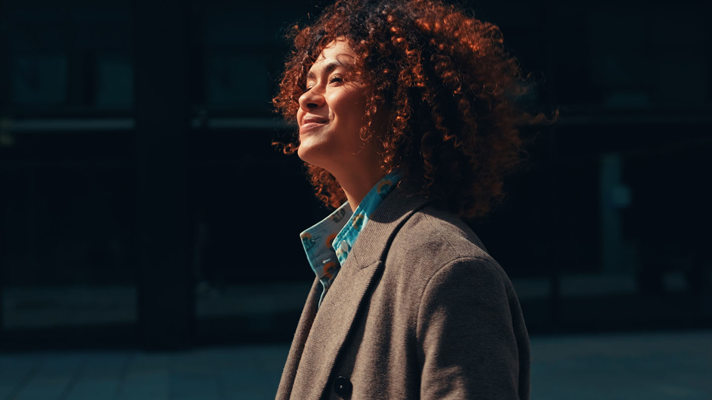 Young woman looking into the sun and smiling