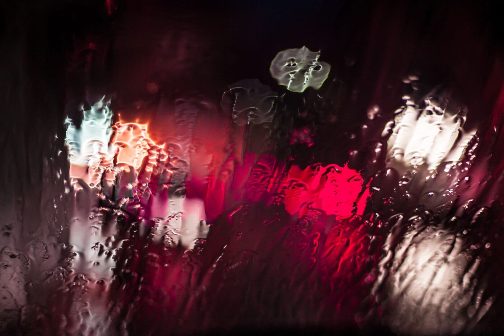 lights shinning through rain soaked glass