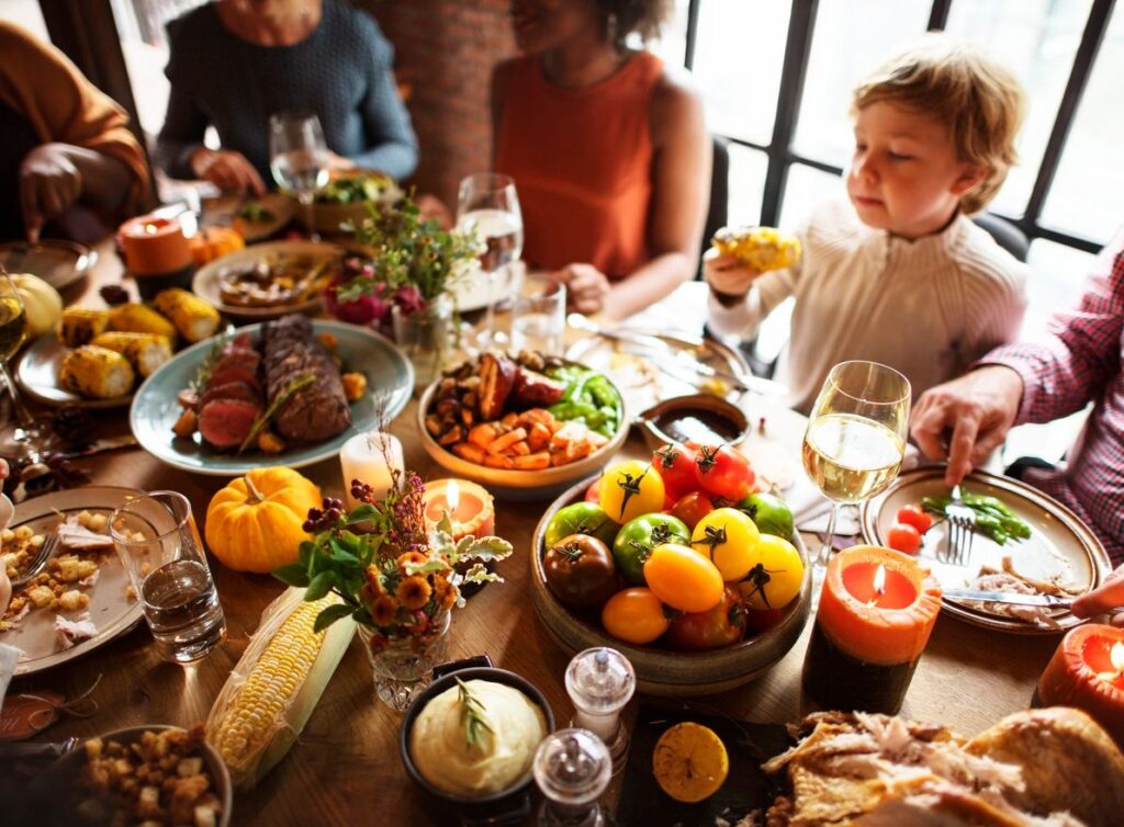 family sitting around a table for a big thanksgiving meal