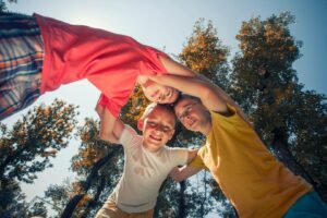3 kids huddled together smiling during summer break