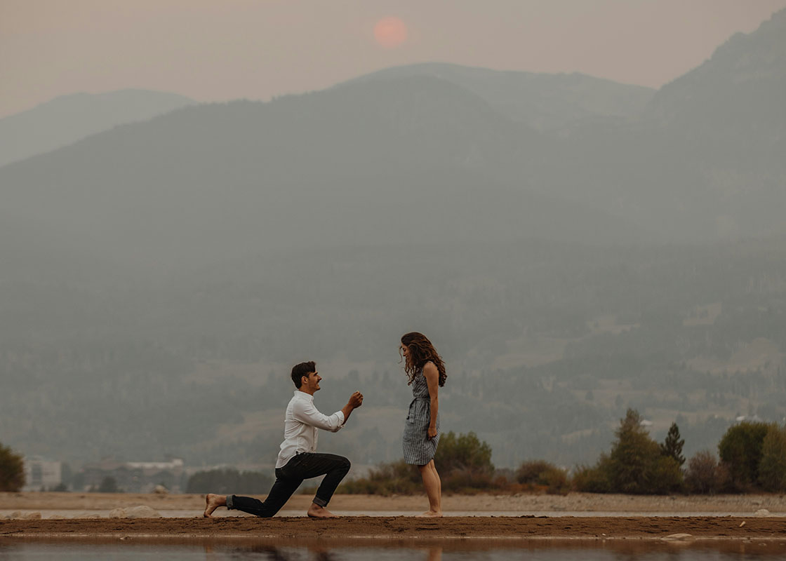 couple getting engaged with foggy mountains in the background